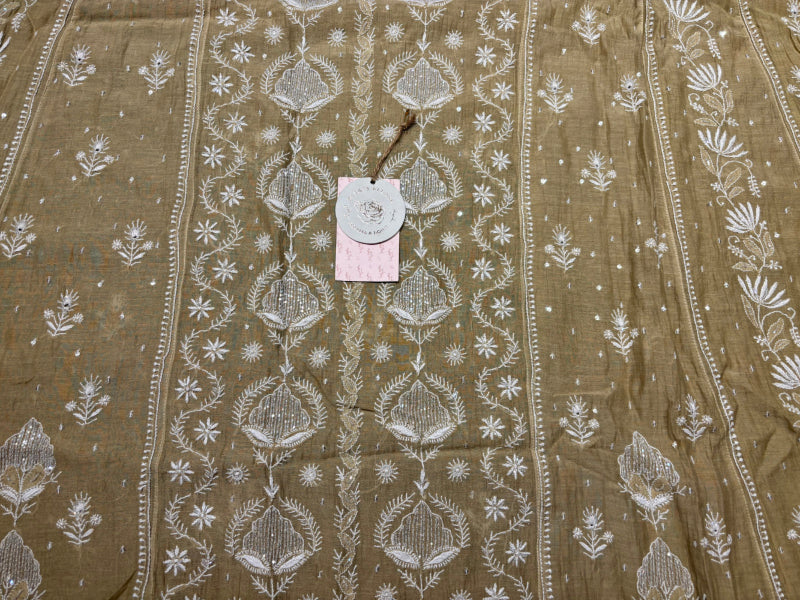 Brown fabric with white floral patterns chanderi mul